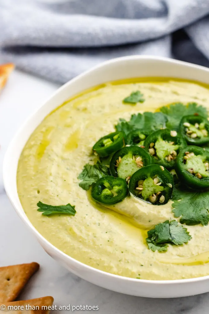 White bowl filled with jalapeno cilantro hummus.