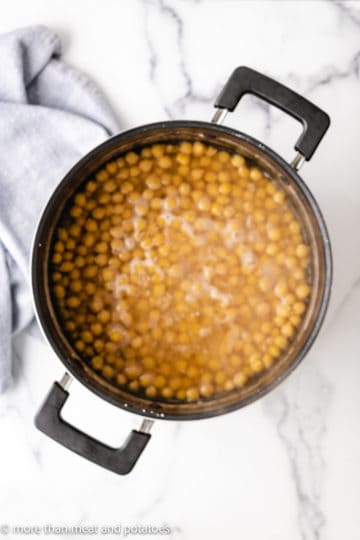 Top down view of cooked chickpeas in a pan.