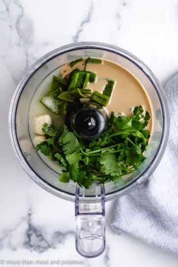 Top down view of ingredients for hummus in a food processor.