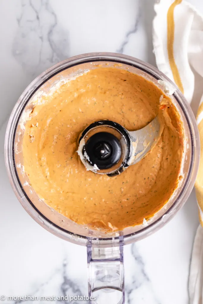 Top down view of roasted red pepper dip in a food processor.