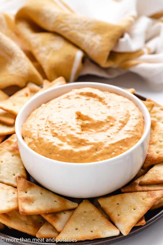 Roasted pepper dip in a dish with crackers.