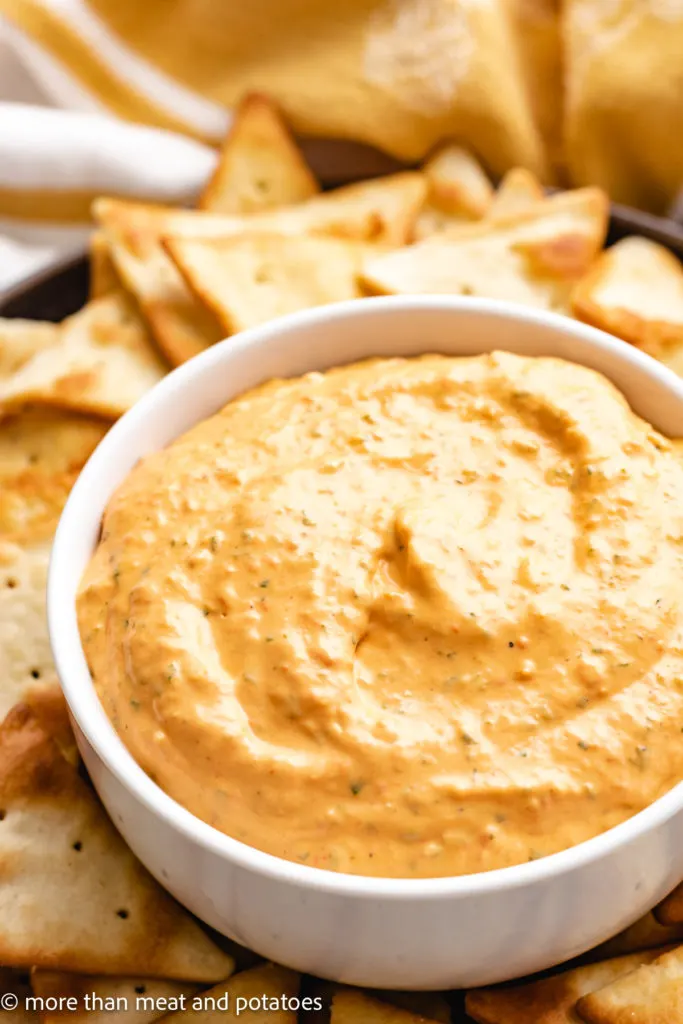 Roasted pepper dip in a bowl with pita chips.