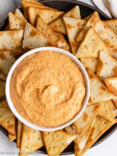 Top down view of roasted red pepper dip on a serving plate.