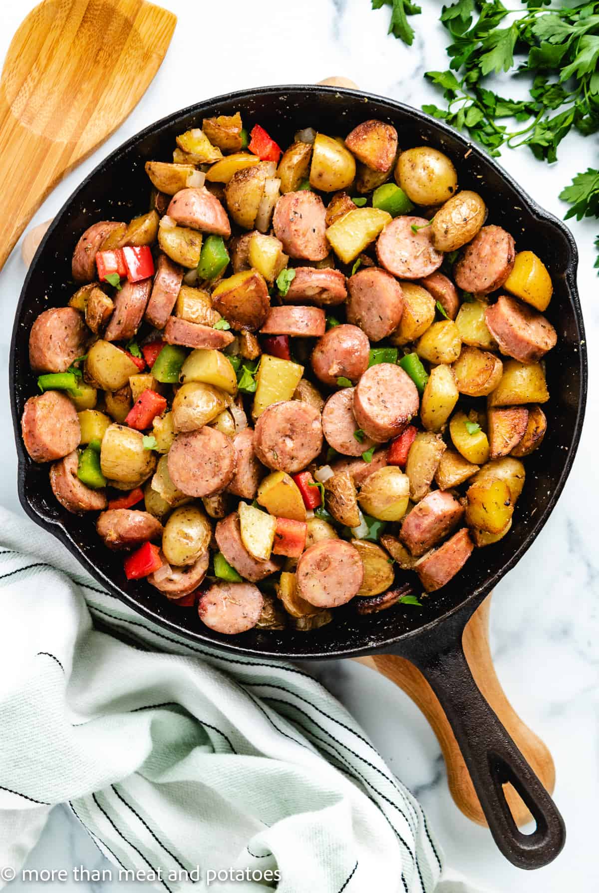 Top down view of potatoes and sausage in a pan.