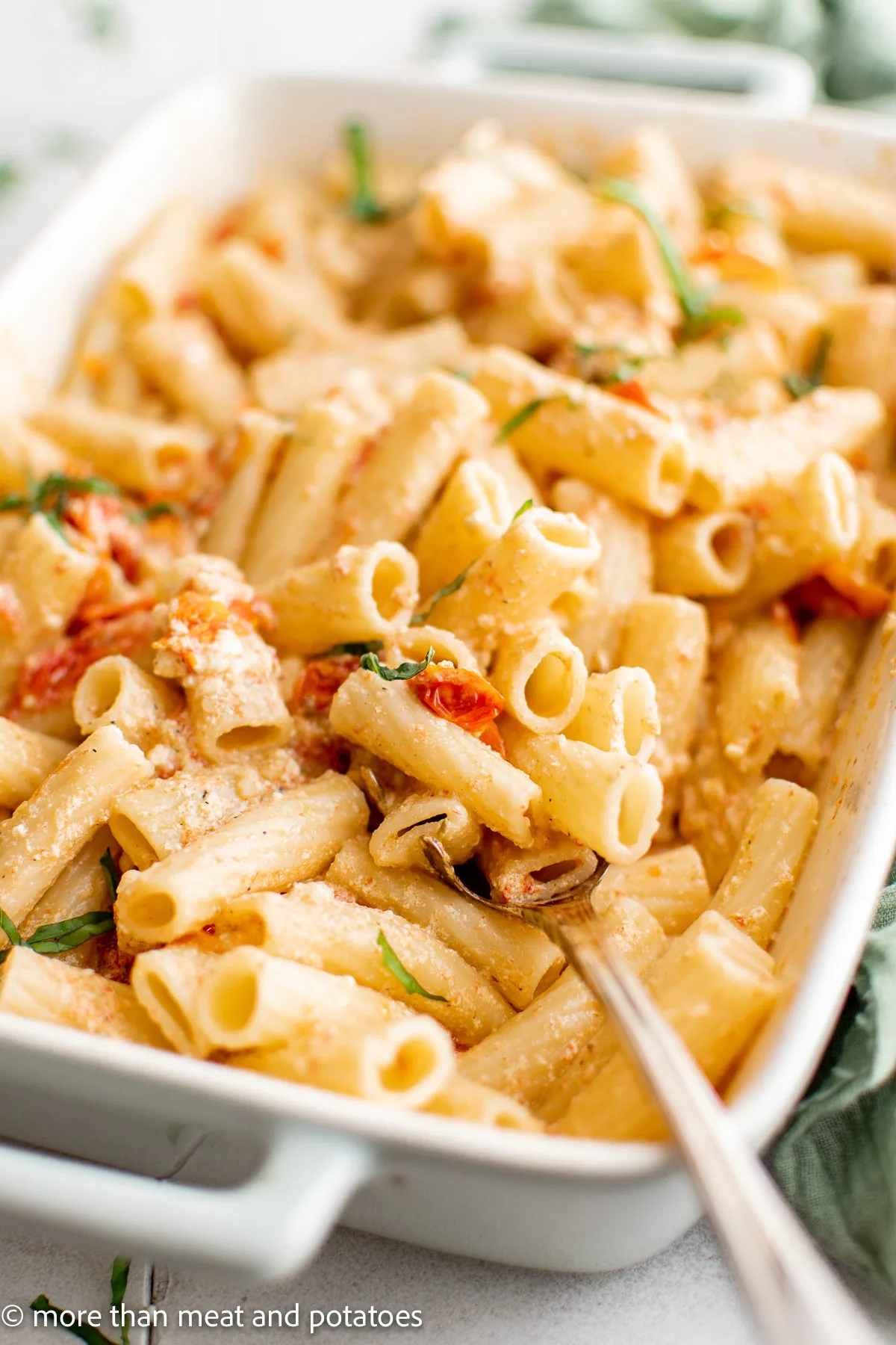 Top down view of baked feta pasta in a baking dish.