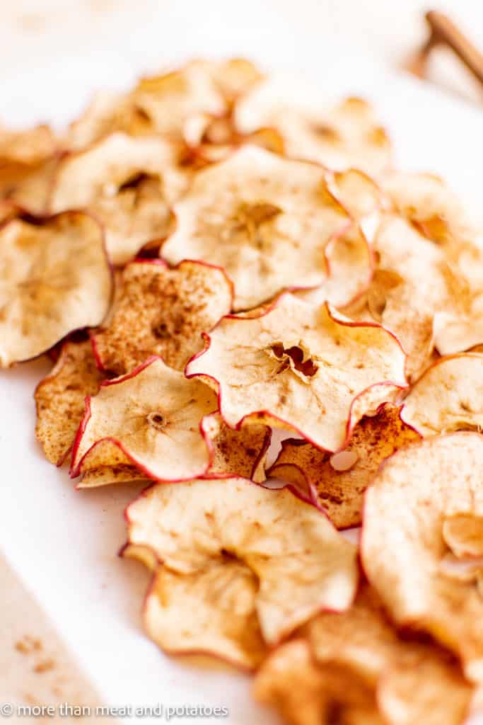 Large white plate filled with apple chips.