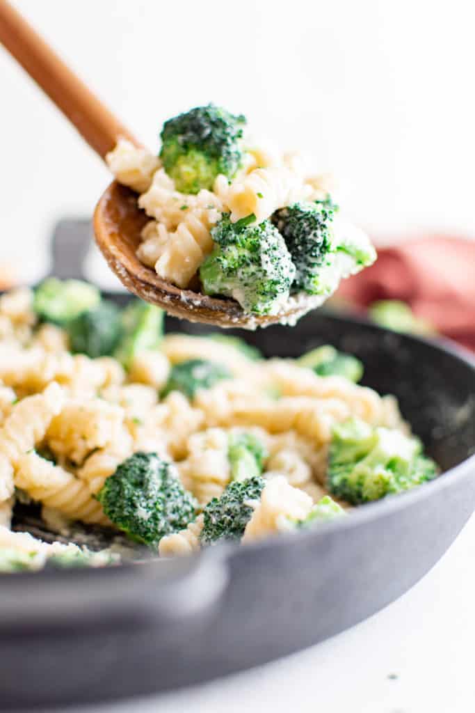 Large serving spoon with broccoli and pasta.