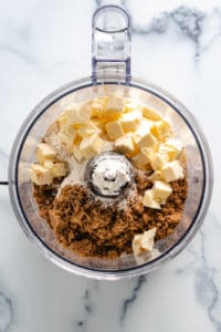 Top down view of crumble topping ingredients in a food processor.
