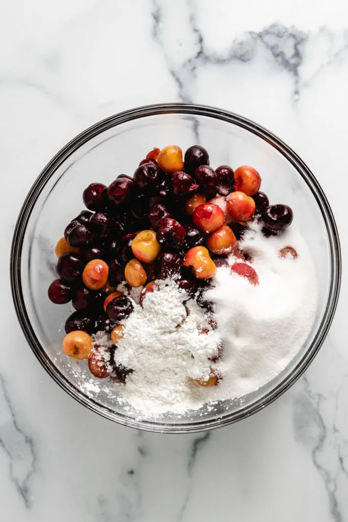 Ingredients for cherry pie filling in a glass bowl.