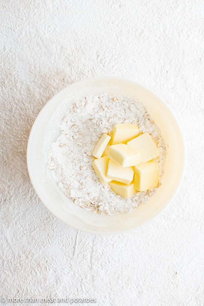 Top down view of oats, flour, butter, and sugar in a bowl.