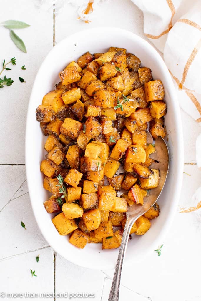 Top down view of a large platter filled with roasted butternut squash.