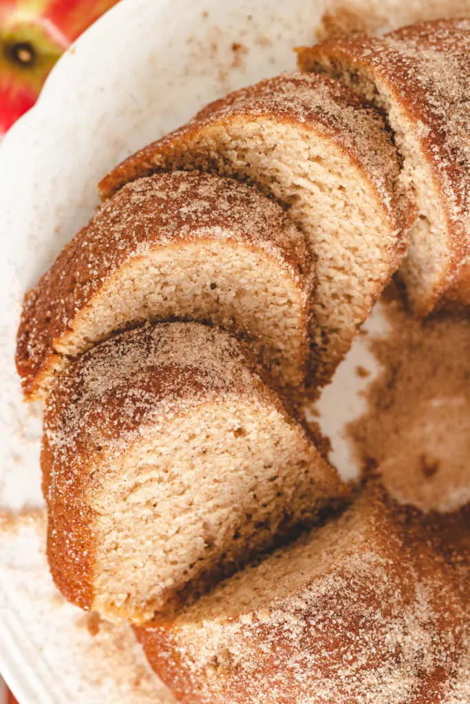 Sliced apple cider donut cake on a cake stand.