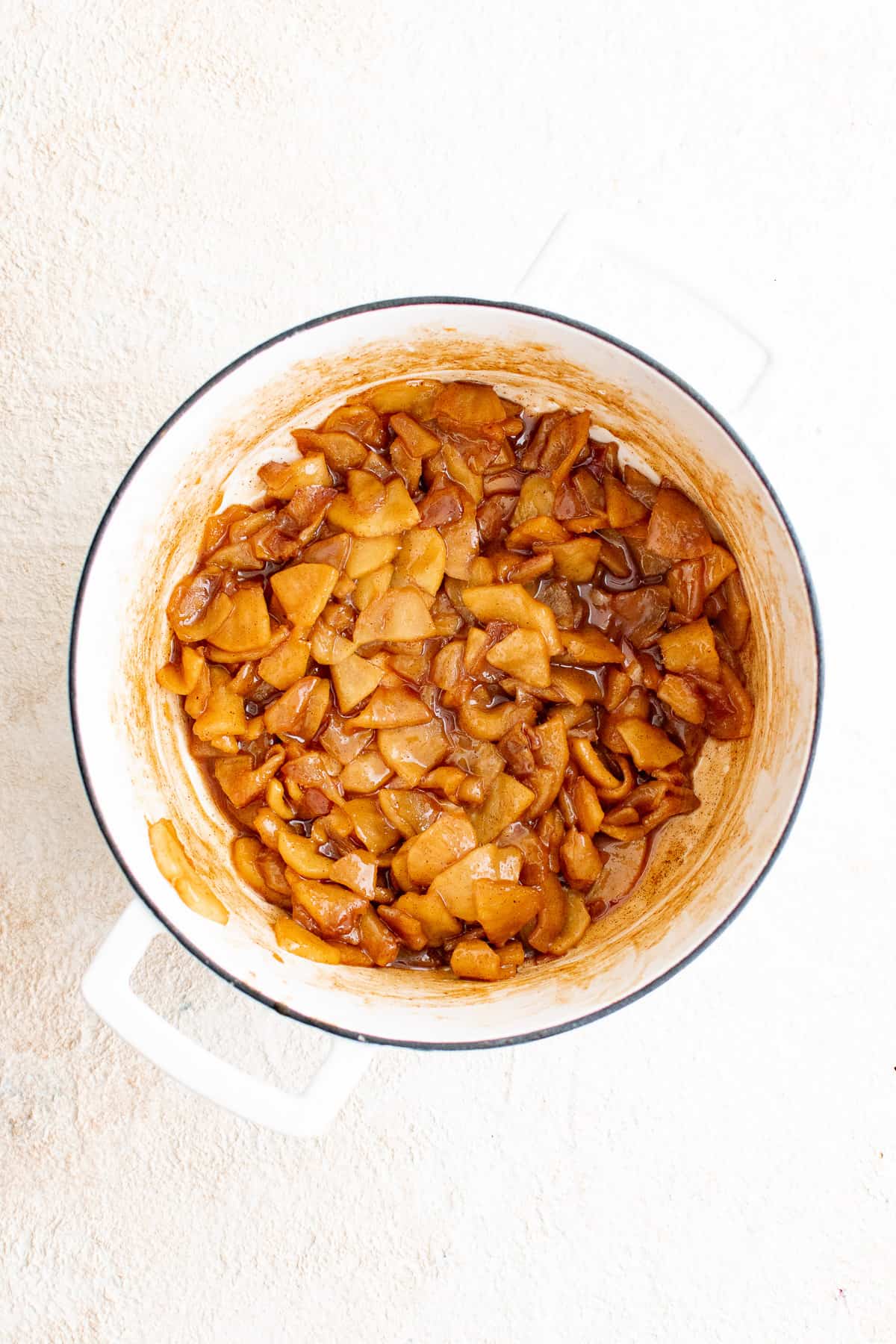 Top down view of apples and spices cooked in a pan.