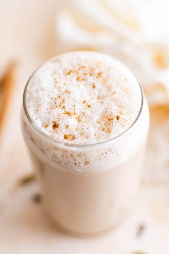 Top down view of iced latte with frothed milk and cinnamon.