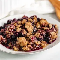 Dish filled with blueberry crisp topped with oat topping.
