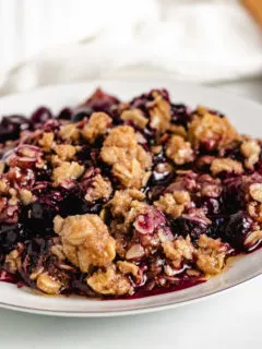 Dish filled with blueberry crisp topped with oat topping.