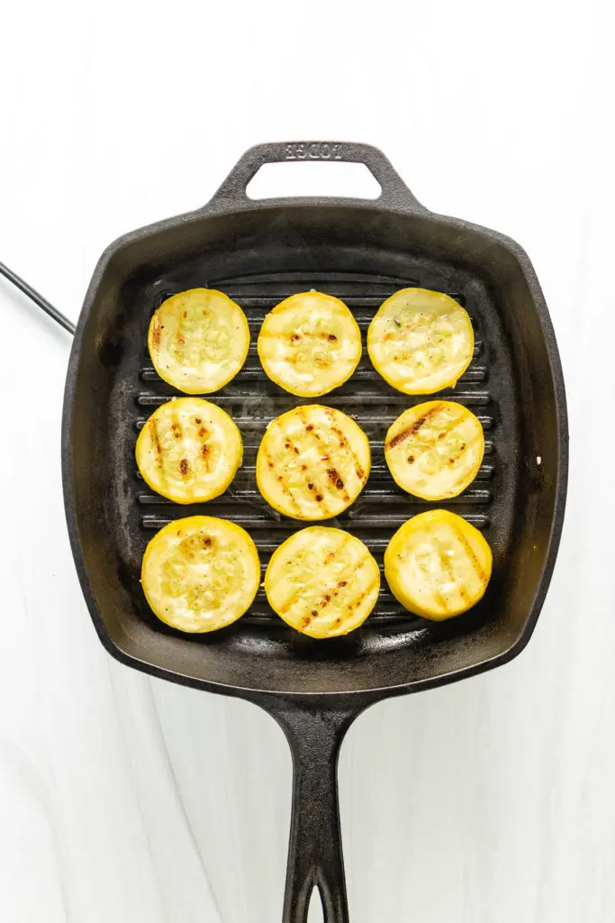 Top down view of squash cooking on a griddle pan.