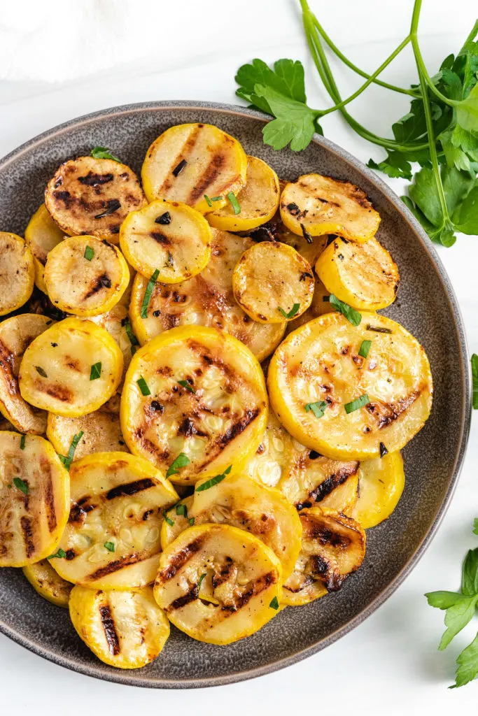 Top down view of grilled squash on a circular plate.