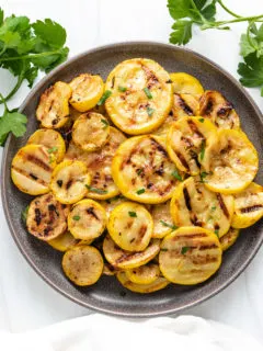 Top down view of squash on a plate with a white towel.