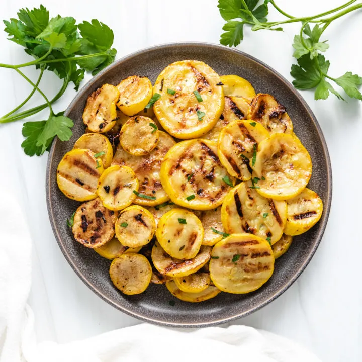 Top down view of squash on a plate with a white towel.