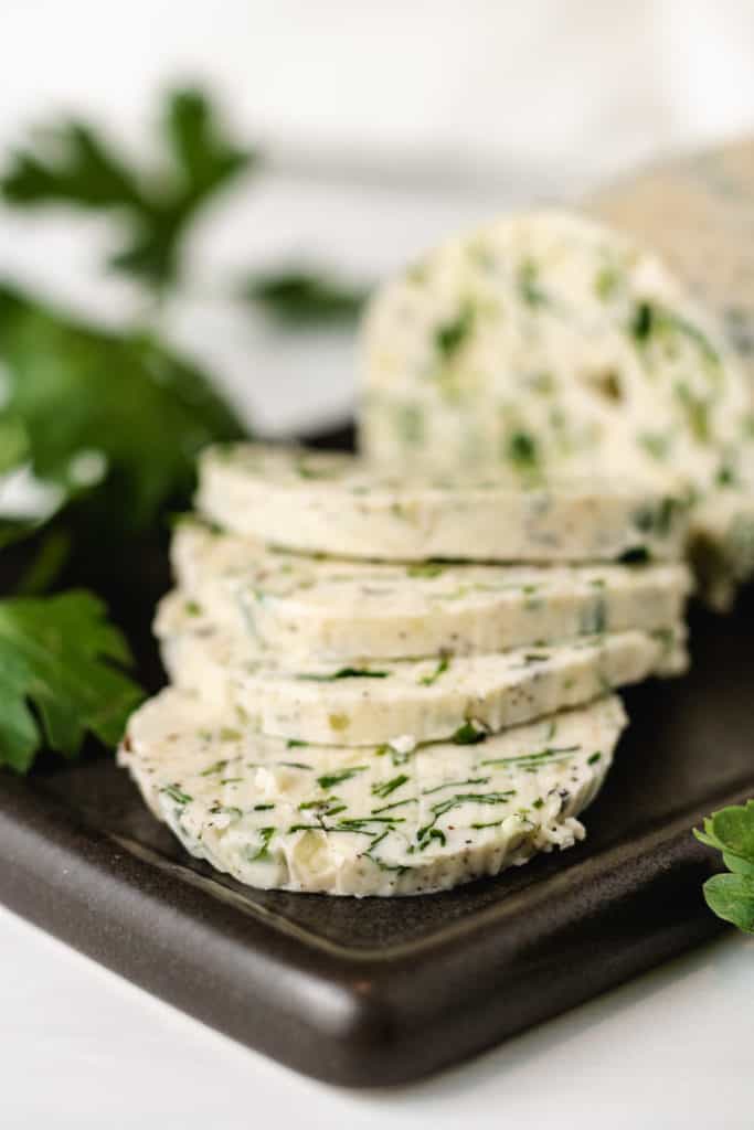 Garlic butter with fresh herbs on a spoon holder.