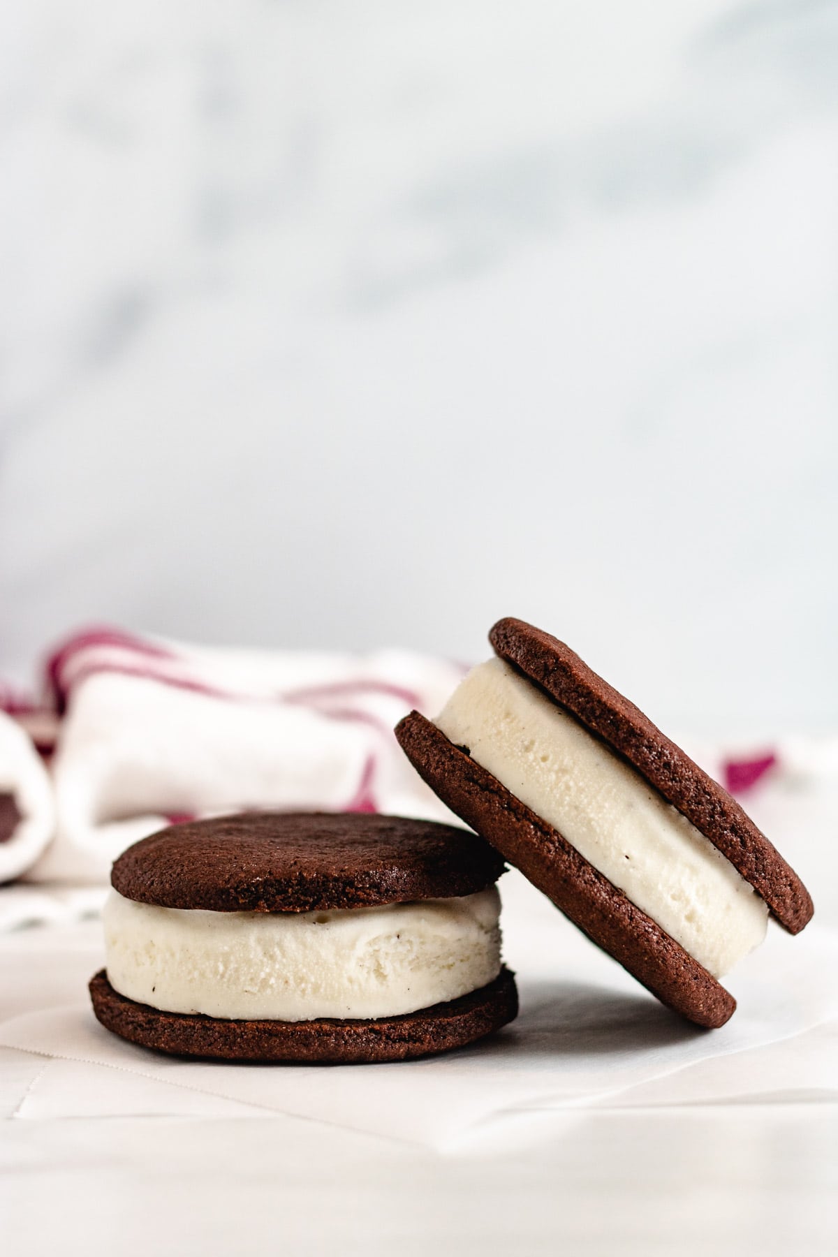 Two ice cream sandwiches on parchment paper.