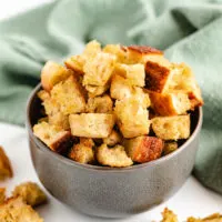 Sourdough croutons in a gray bowl with a green linen.