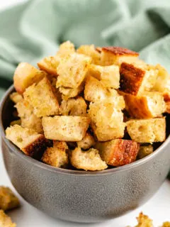 Sourdough croutons in a gray bowl with a green linen.