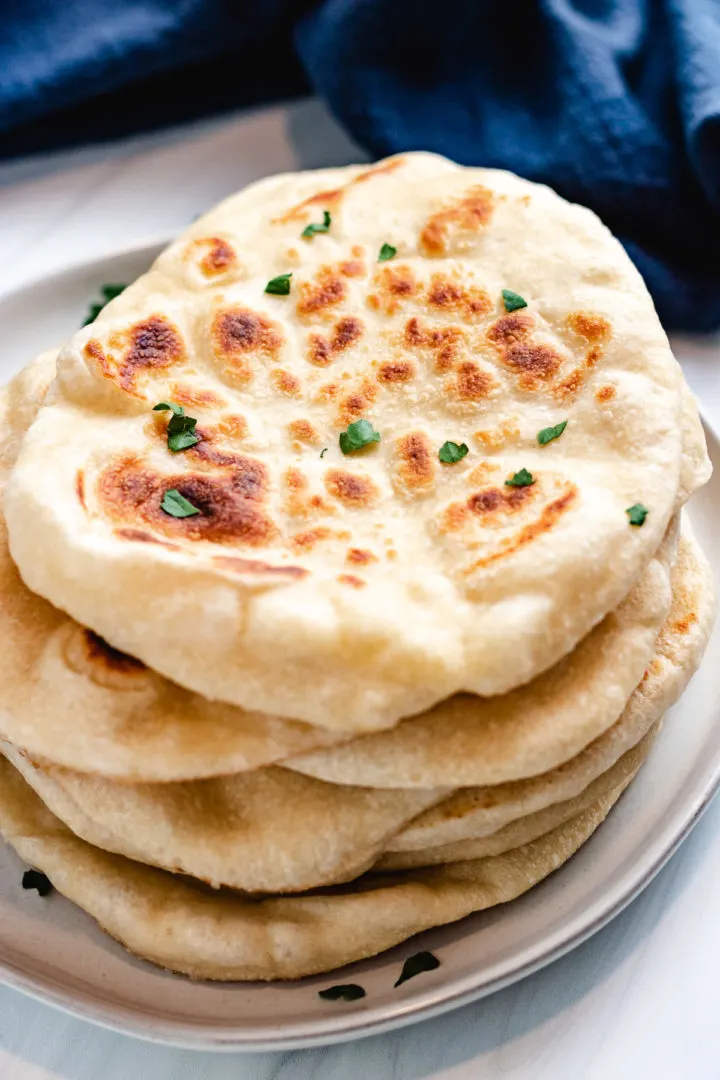 Sourdough naan on a gray plate.