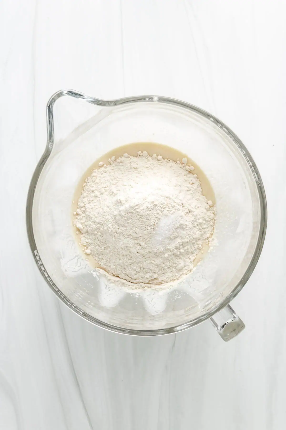 Top down view of flour on top of wet ingredients.