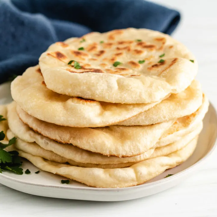 Several pieces of naan bread on a gray plate.