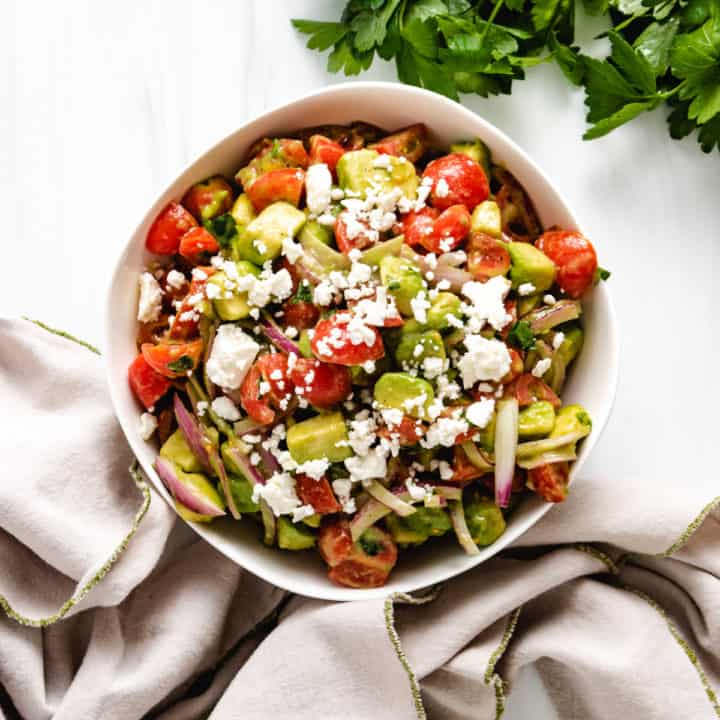 Top down view of tomato avocado salad with fresh parsley.