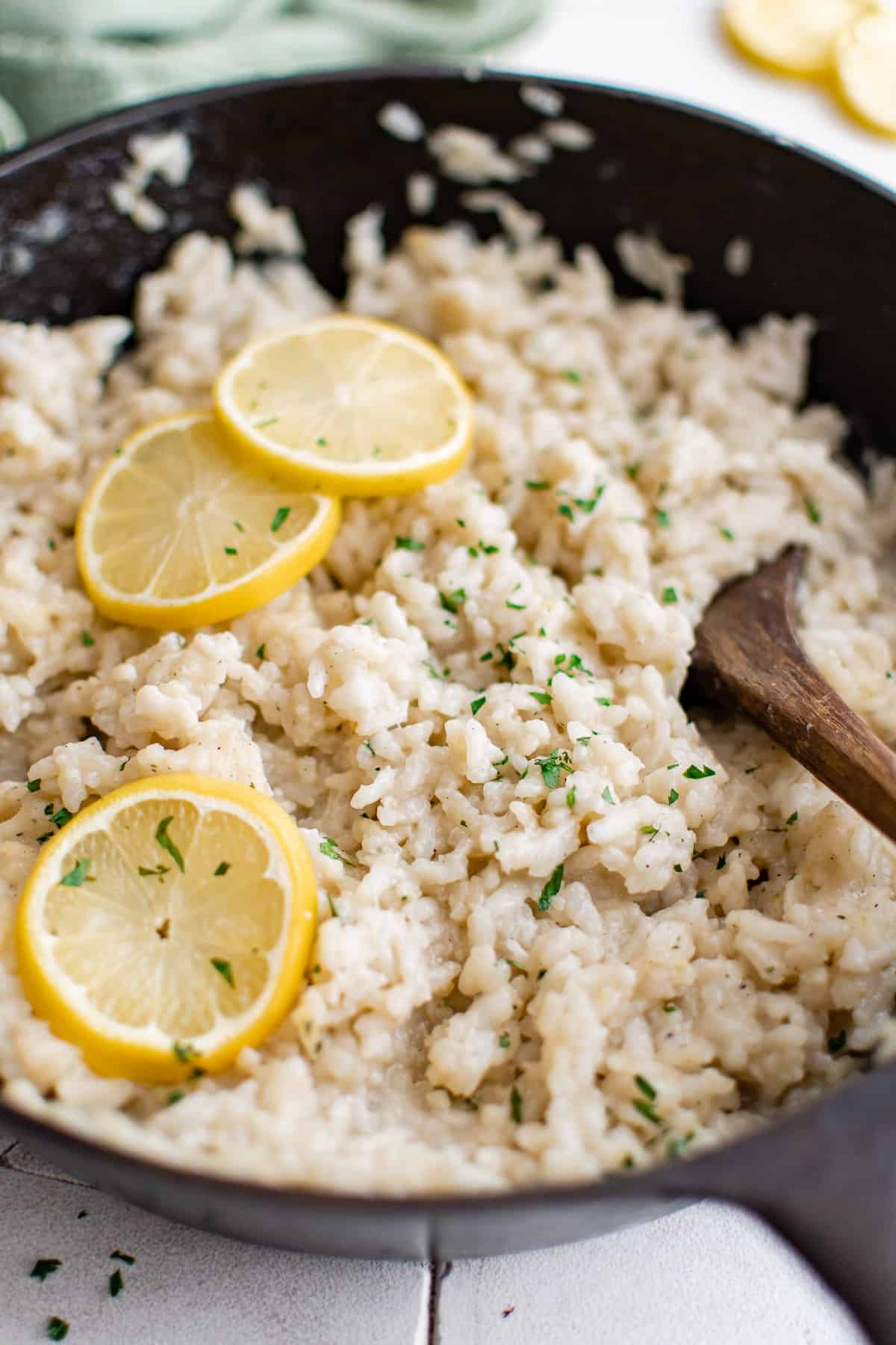 Close up view of risotto with lemon slices in a pan.