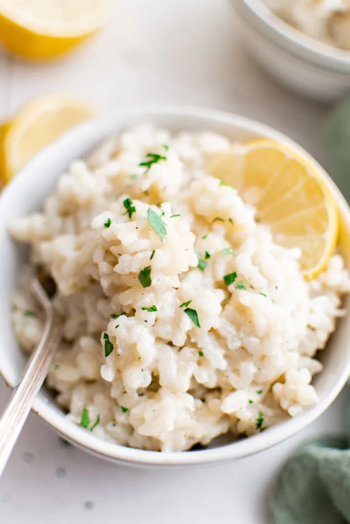 Top down view of parmesan risotto with a lemon slice.