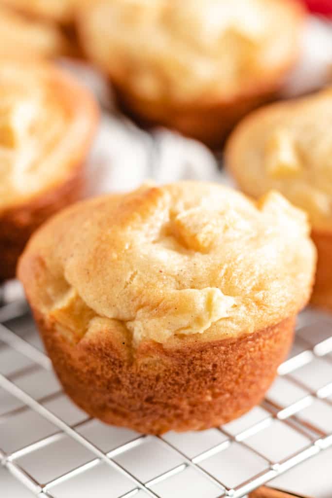 Close up of an apple cinnamon muffin on a rack.