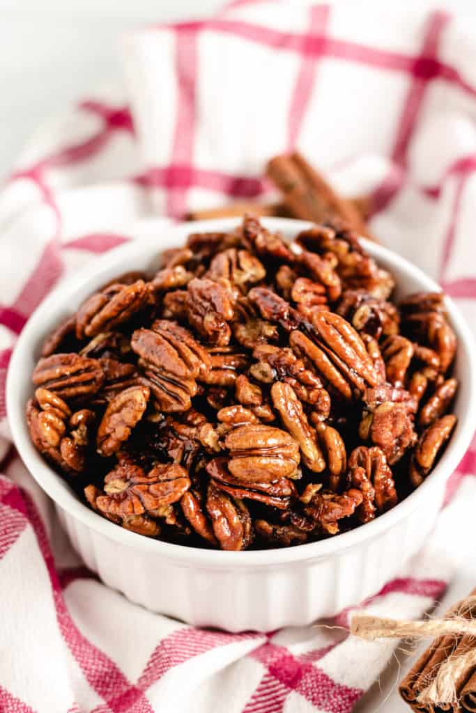 White bowl filled with candied pecans.