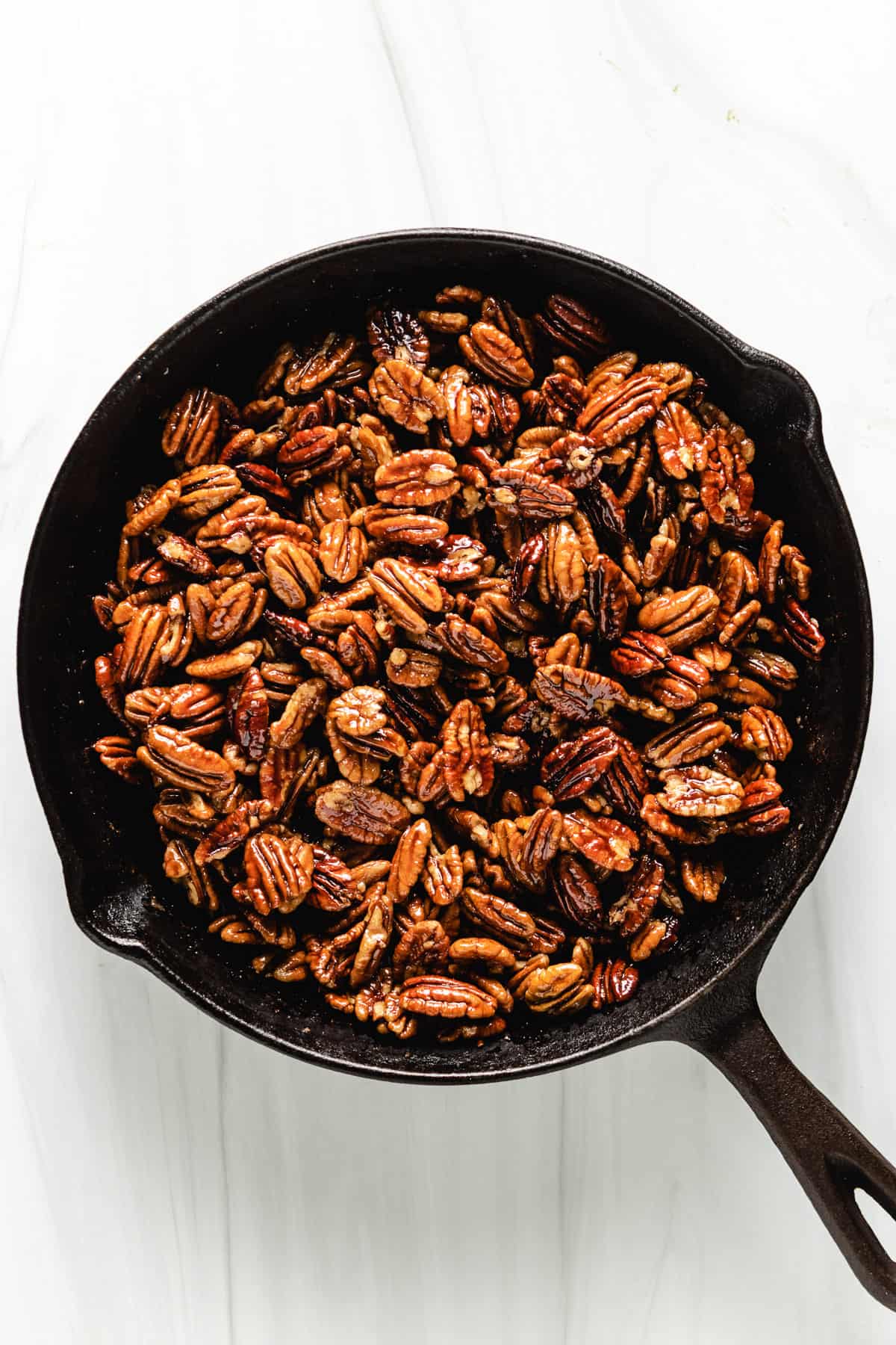 Cast iron pan filled with candied pecans.