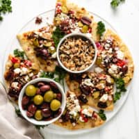 Top down view of sliced naan bread with toppings.