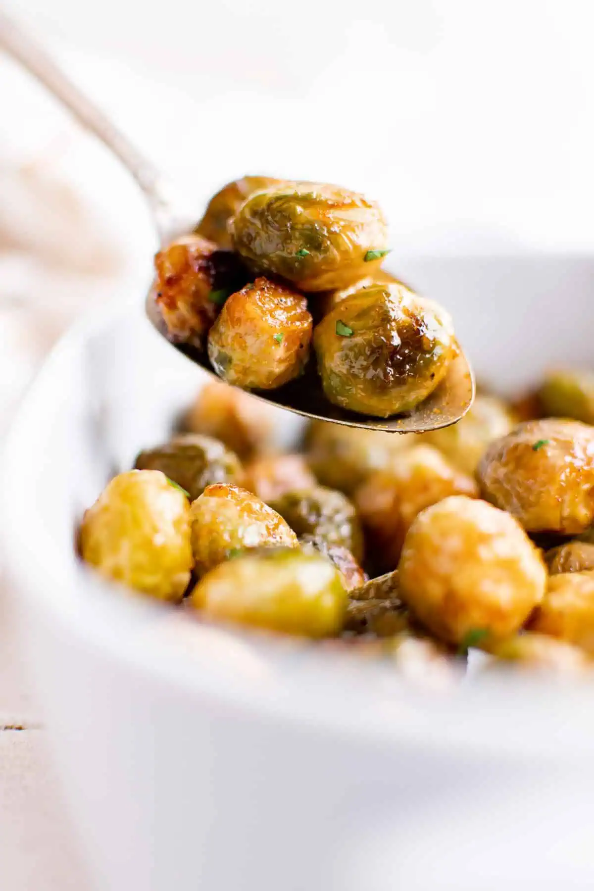 Brussel sprouts being scooped into a bowl.