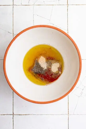 Top down view of honey sriracha ingredients in a bowl.