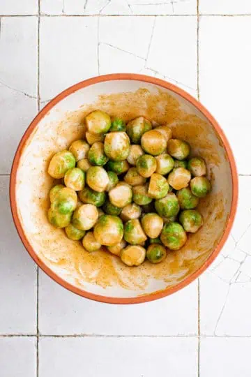 Top down view of brussel sprouts tossed with honey sriracha glaze.