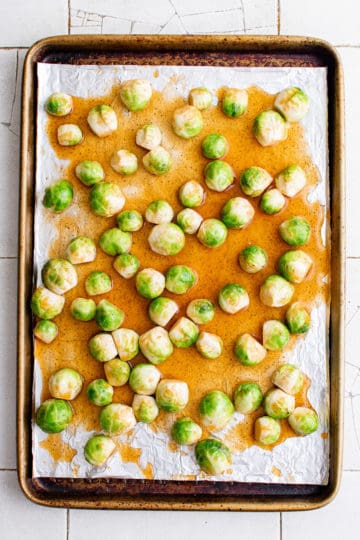 Top down view of uncooked brussel sprouts on a pan.