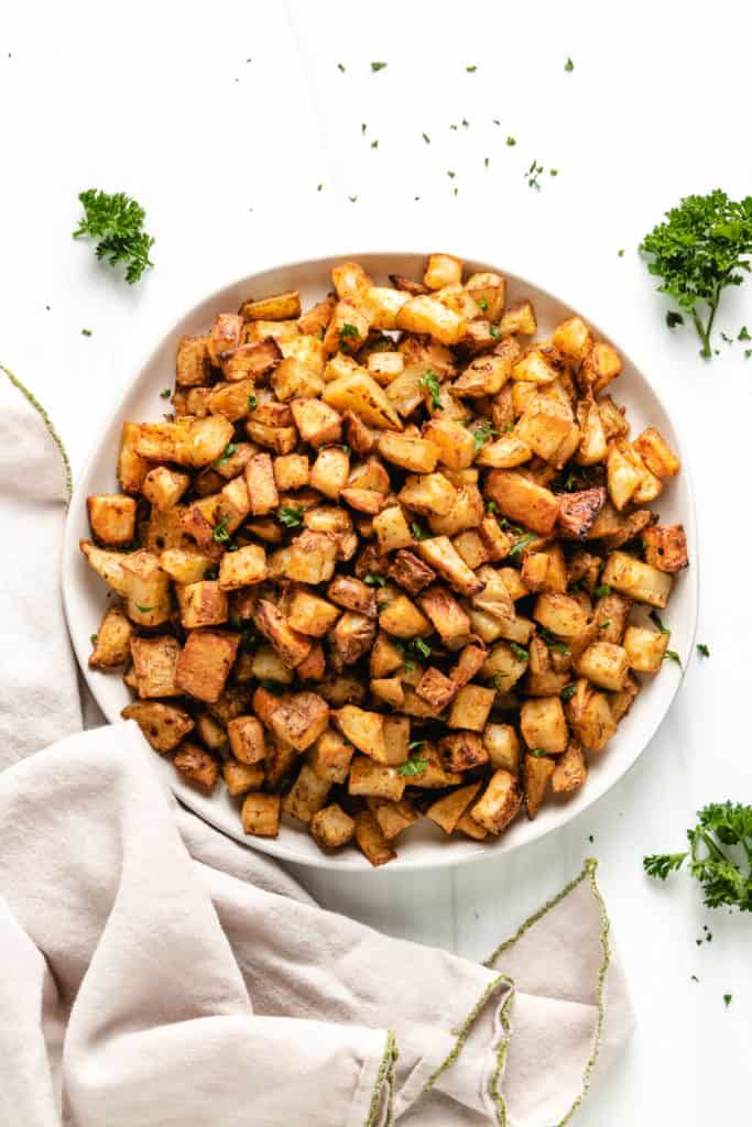 Top down view of roasted potatoes on a round plate.