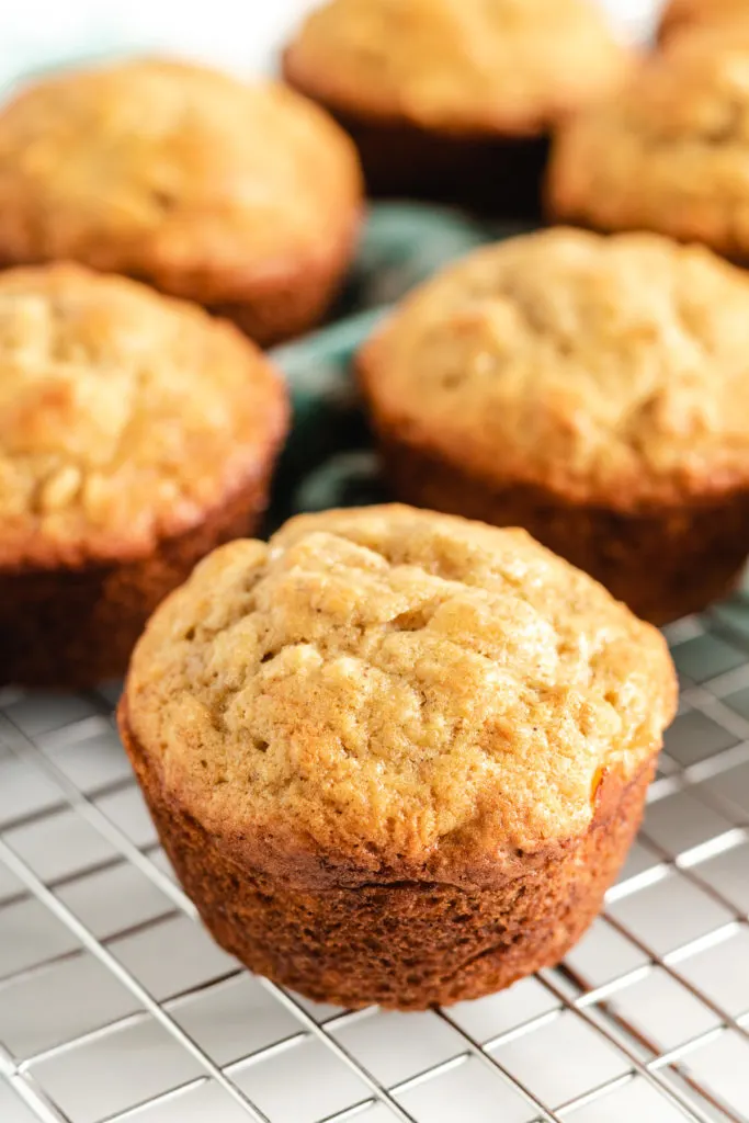 Several banana oatmeal muffins on a cooling rack.