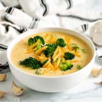 White bowl of broccoli cheddar soup.