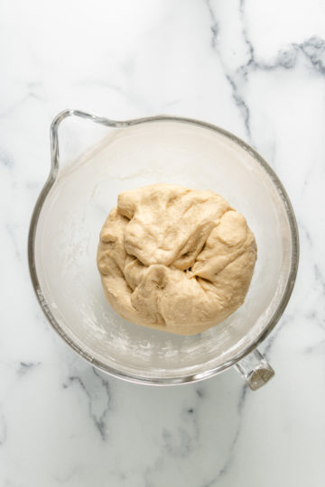 Dough for rolls in a mixing bowl.
