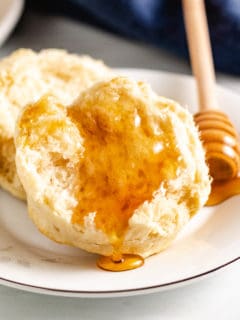 Half a sourdough biscuit topped with honey.