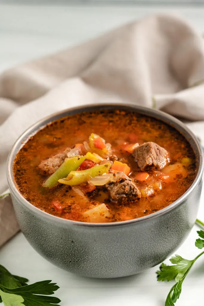 Gray bowl filled with vegetable beef soup.