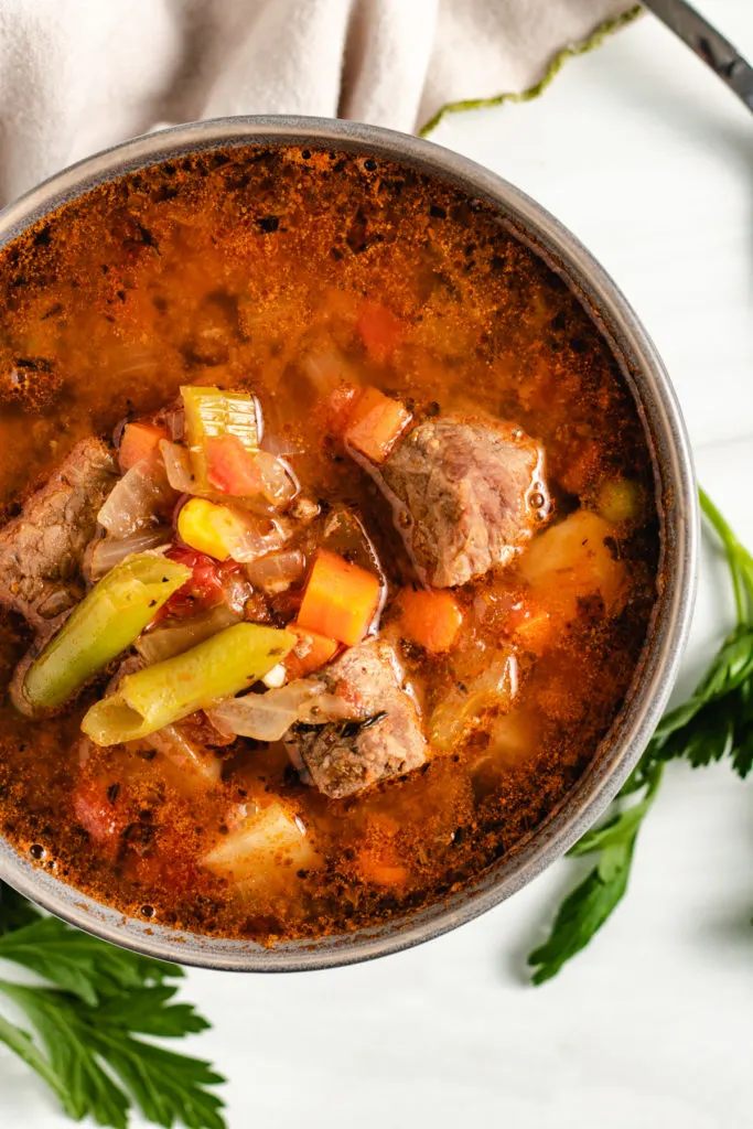 Top down view of vegetable beef soup in a bowl.