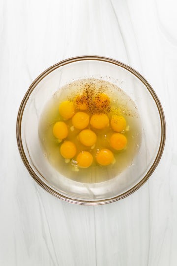 Eggs and seasonings in a bowl.